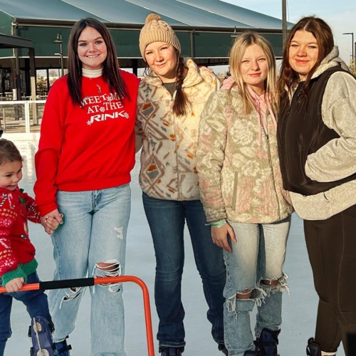 a group of people posing for a photo on an ice rink