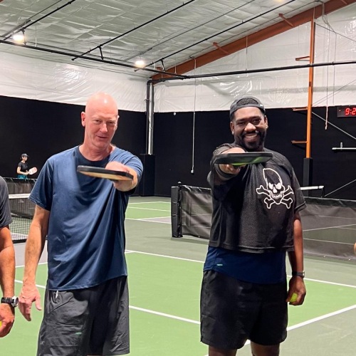 a group of people pose for a photo on a tennis court